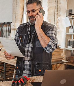 man looking at document while talking on phone